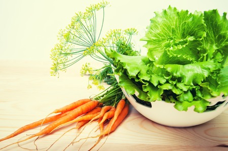 Carrots, salad and fennel on wooden tableの写真素材