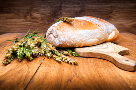 Fresh bread and wheat on wooden backgroundの写真素材