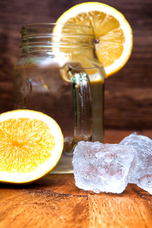 Cold fresh lemonade drink and ice cubes on wooden backgroundの写真素材