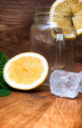Cold fresh lemonade drink and ice cubes on wooden backgroundの写真素材
