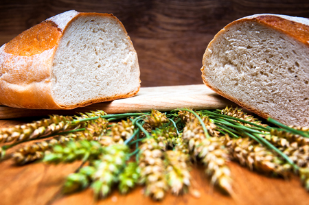 Fresh bread and wheat on wooden backgroundの写真素材