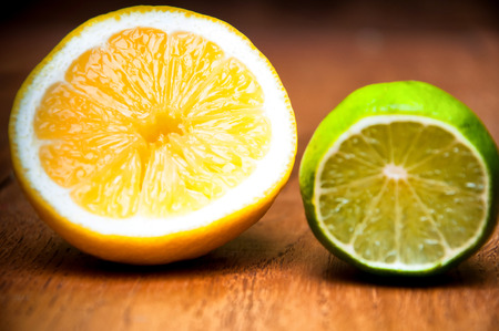 Ripe lemons and limes over black wooden backgroundの写真素材