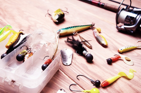 Fishing baits and rod isolated on wooden backgroundの写真素材