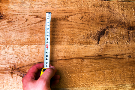 Hand with measuring tool on wooden tableの写真素材