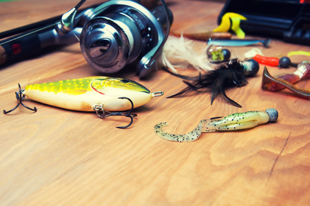 Fishing baits and rod isolated on wooden backgroundの写真素材