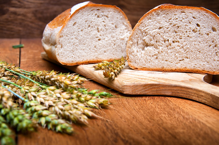 Fresh bread and wheat on wooden backgroundの写真素材