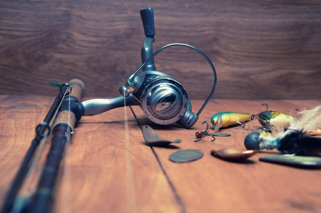 Fishing baits and rod isolated on wooden backgroundの写真素材