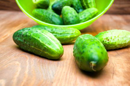 Mini cucumbers in bowl on tableの写真素材