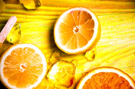 Juicy fruits and ice cubes on wooden backgroundの写真素材