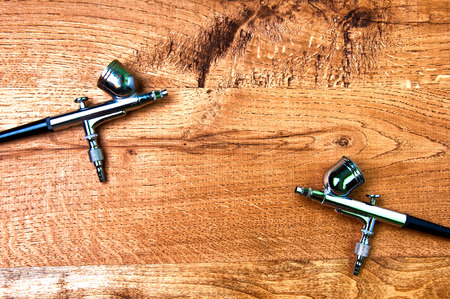 Two airbrushes on wooden backgroundの写真素材
