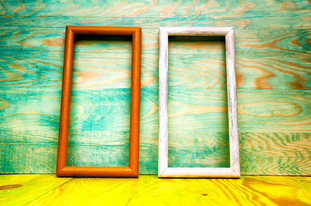 Old abstract picture frames on colored wooden background