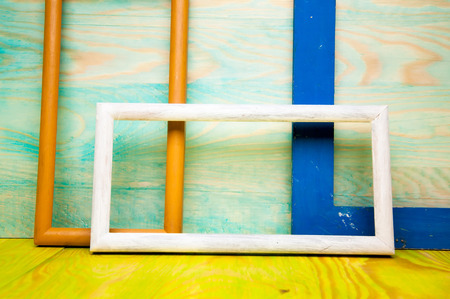 Old abstract picture frames on colored wooden backgroundの写真素材