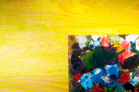 Painting palette on colored wooden background