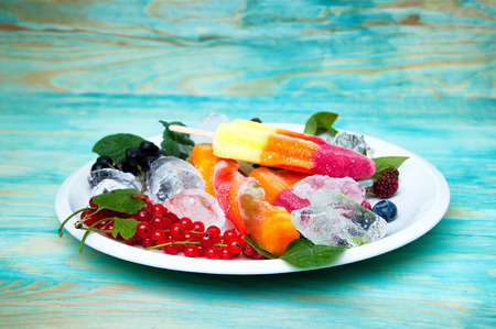 Composition of delicious ice cream, fruits and ice cubes