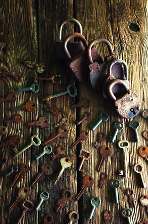 Old rusty padlock and keys on wooden backgroundの写真素材
