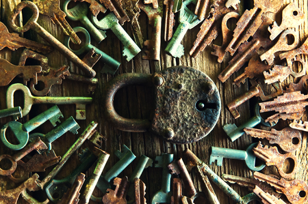 Old rusty padlock and keys on wooden backgroundの写真素材