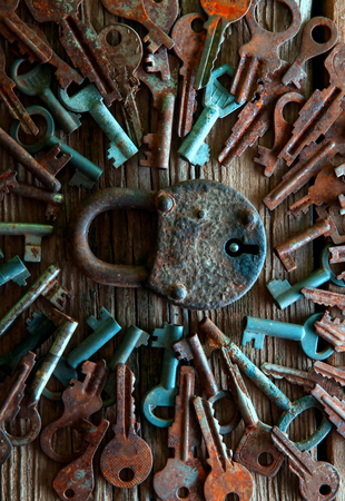 Old rusty padlock and keys on wooden backgroundの写真素材