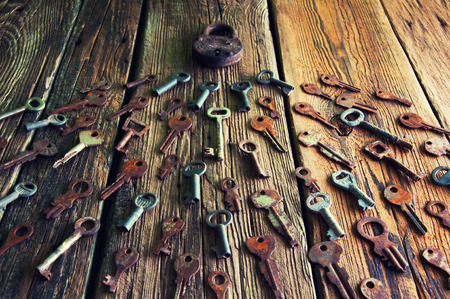 Old rusty padlock and keys on wooden backgroundの写真素材