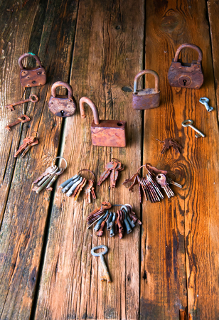 Old rusty padlock and keys on wooden backgroundの写真素材
