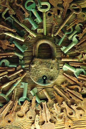 Old rusty padlock and keys on wooden backgroundの写真素材