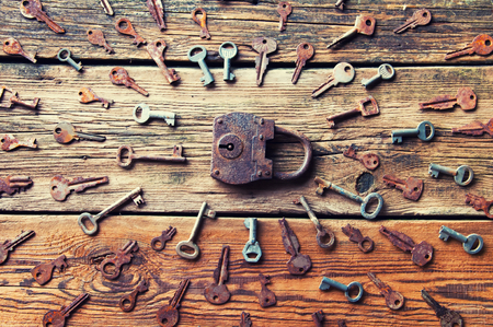 Old rusty padlock and keys on wooden backgroundの写真素材