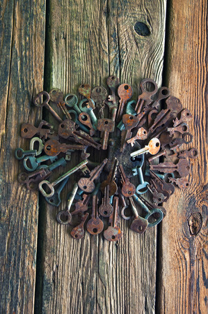 Old rusty padlock and keys on wooden backgroundの写真素材