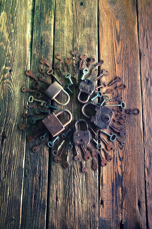 Old rusty padlock and keys on wooden backgroundの写真素材