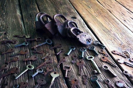 Old rusty padlock and keys on wooden backgroundの写真素材