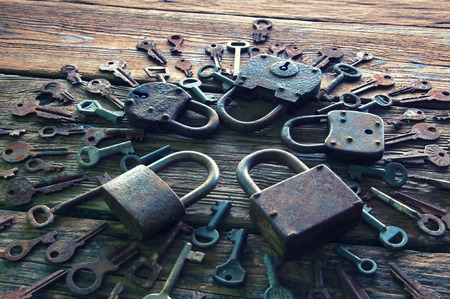 Old rusty padlock and keys on wooden backgroundの写真素材
