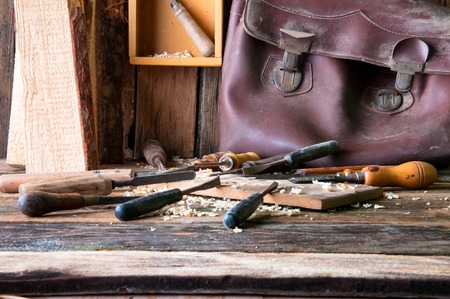 Chisels and carved piece of wood in traditional carpenter workshopの写真素材