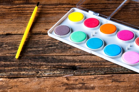Poster paints and brush on vintage wooden table. Copyspaceの写真素材