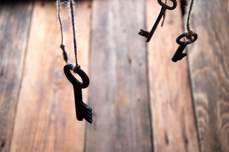 Many keys hanging on a string. Wooden background. Selective focusの写真素材