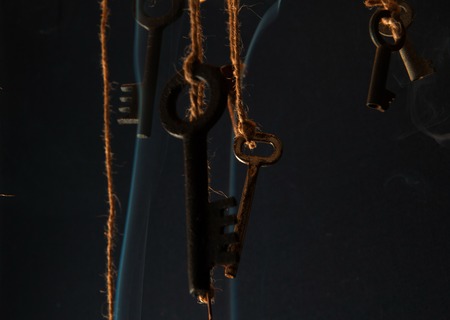 Keys hanging on a string. Smoke background. Selective focusの写真素材