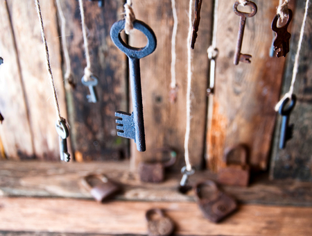 Many keys hanging on a string. Wooden background. Selective focusの写真素材