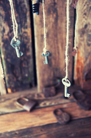 Many keys hanging on a string. Wooden background. Selective focusの写真素材