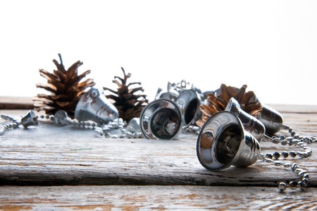 Silver christmas tree bells on white wooden background. Copyspaceの写真素材