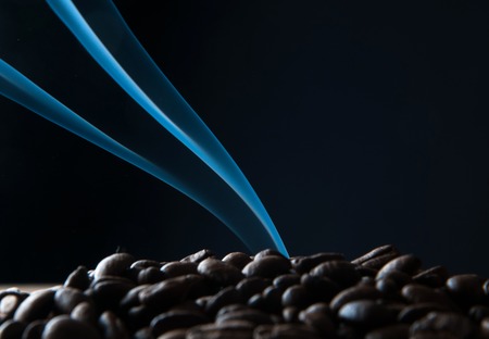 Smoke rising over roasted coffee beansの写真素材