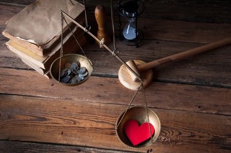 Old fashioned scale showing the advantage of love over moneyの写真素材