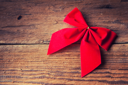 Red bow on wooden background. Copspace. Top viewの写真素材