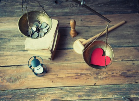 Old fashioned scale showing the advantage of love over moneyの写真素材