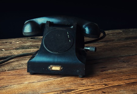 Old-fashioned landline telephone on dark wooden backgroundの写真素材