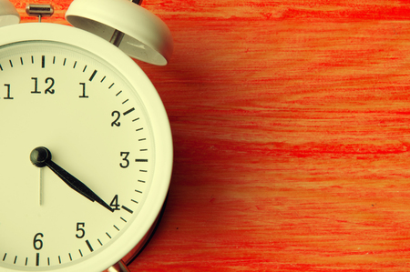 White alarm clock on red background. Copyspaceの写真素材