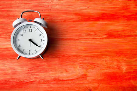White alarm clock on red background. Copyspaceの写真素材