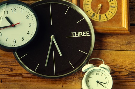 Many different clocks on wooden tableの写真素材
