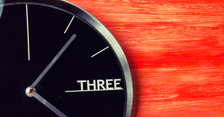 Black clock on wooden table, copyspaceの写真素材
