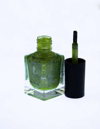 A bottle of green nail polish with mica in an isolated picture. Nail polish bottle open.の写真素材