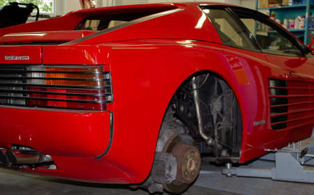Photo of a Ferrari Testarossa jacked up with the wheels removed. Photographed from the back right.のeditorial素材