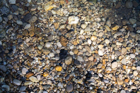 Texture of river pebbles half under water.の写真素材