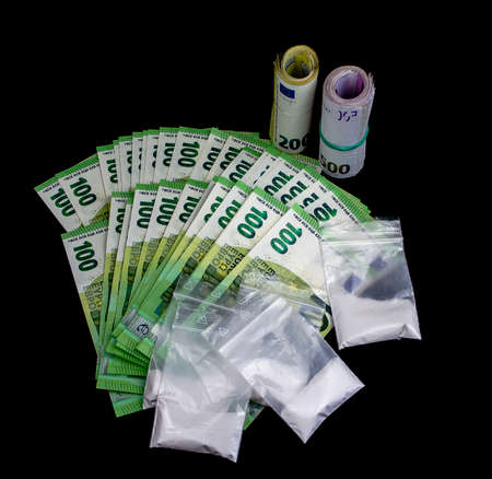 Many euro notes lying and also rolled. There are plastic bags with drugs on it.の写真素材