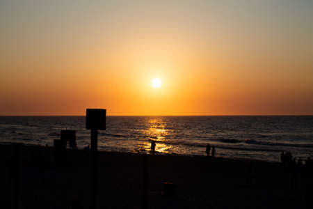 Romantic sunset by the sea. The setting sun over the waves.の写真素材
